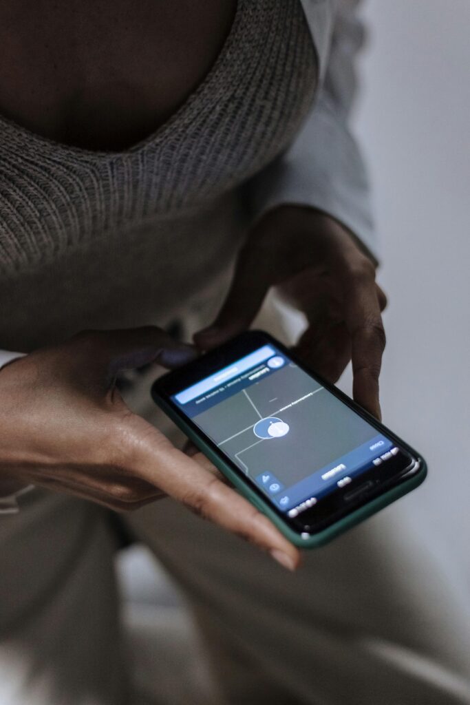 Close-up of a woman holding a smartphone with GPS navigation displayed, emphasizing technology and connectivity.